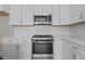 Close up of kitchen with stainless steel appliances, white backsplash, and white quartz countertops at 716 Jamescroft Way # 28, Rolesville, NC 27571