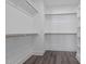 Spacious walk-in closet with wood-look flooring, wooden rods and built in shelving at 716 Jamescroft Way # 28, Rolesville, NC 27571