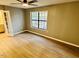 Spacious bedroom featuring a ceiling fan, large window, and beautiful, light-colored hardwood floors at 7708 Falcon Rest Cir, Raleigh, NC 27615