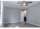 Bright bedroom featuring a ceiling fan, large window, and beautiful, gray hardwood floors at 7708 Falcon Rest Cir, Raleigh, NC 27615