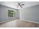 This bedroom features a ceiling fan and a window providing natural light at 7708 Falcon Rest Cir, Raleigh, NC 27615