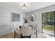 Bright dining area features paneled wall, a modern light fixture, and backyard view at 7708 Falcon Rest Cir, Raleigh, NC 27615