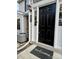 Close-up of the front door with a 'welcome' mat, black door, and white trim at 7708 Falcon Rest Cir, Raleigh, NC 27615