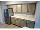 Kitchen featuring stainless refrigerator, tile backsplash, light wood floors, and neutral cabinetry at 7708 Falcon Rest Cir, Raleigh, NC 27615
