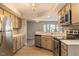 Well-lit kitchen features stainless appliances, neutral cabinets, tile backsplash and wood flooring at 7708 Falcon Rest Cir, Raleigh, NC 27615