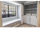 Bright laundry room with storage, sliding door, window seat and modern washer and dryer at 7708 Falcon Rest Cir, Raleigh, NC 27615