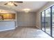 Open living room into kitchen and features sliding glass door leading outside and neutral walls at 7708 Falcon Rest Cir, Raleigh, NC 27615