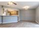 Neutral living room leading into kitchen area with modern ceiling fan and wood flooring at 7708 Falcon Rest Cir, Raleigh, NC 27615