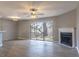 Open living room features neutral walls, fireplace, modern ceiling fan and sliding glass doors at 7708 Falcon Rest Cir, Raleigh, NC 27615
