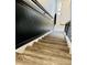 Staircase going down to lower level with wood look steps and wainscoting at 7708 Falcon Rest Cir, Raleigh, NC 27615