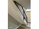 Staircase with black railing and light gray walls leads to the front door and tiled foyer at 7708 Falcon Rest Cir, Raleigh, NC 27615