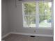 Bright bedroom featuring a large window with blinds and neutral carpet at 7746 Kingsberry Ct, Raleigh, NC 27615
