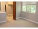 Bright bedroom featuring a large window, neutral carpet, and closet space for ample storage at 7746 Kingsberry Ct, Raleigh, NC 27615