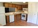 Functional kitchen with wood cabinets, white appliances, and a tiled backsplash at 7746 Kingsberry Ct, Raleigh, NC 27615