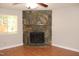 Living room featuring a stone fireplace, ceiling fan, and a bright window at 7746 Kingsberry Ct, Raleigh, NC 27615