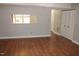 Open living room with hardwood floors, view to the kitchen, and access to hallway at 7746 Kingsberry Ct, Raleigh, NC 27615