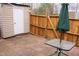 Outdoor patio featuring brick pavers, wooden fence, storage shed, and a table with umbrella at 7746 Kingsberry Ct, Raleigh, NC 27615