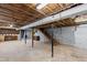 Spacious unfinished basement with exposed ceiling, block walls, and wooden staircase at 817 Glen Eden Dr, Raleigh, NC 27612