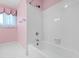A fully tiled, pink-walled bathroom with a bright white bathtub, and shower at 817 Glen Eden Dr, Raleigh, NC 27612
