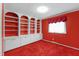 Bedroom with a built in shelving unit, cabinets, and a window with red curtains at 817 Glen Eden Dr, Raleigh, NC 27612