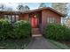 Inviting front entrance featuring double red doors, manicured bushes, and a concrete walkway at 817 Glen Eden Dr, Raleigh, NC 27612