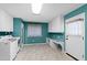 Bright laundry room with white appliances and built-in desk and cabinets, offering convenient functionality at 817 Glen Eden Dr, Raleigh, NC 27612