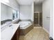 Large bathroom featuring a soaking tub, glass-enclosed shower, and modern fixtures, creating a relaxing retreat at 9100 Palm Bay Cir, Raleigh, NC 27617