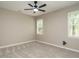 Neutral bedroom with ceiling fan, gray carpet and two windows at 102 Ventura Woods Ct, Wake Forest, NC 27587