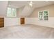 Bonus room featuring built in shelves, neutral carpet, white wainscoting, and two windows at 102 Ventura Woods Ct, Wake Forest, NC 27587