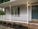 Charming front porch with white railings, brick accents, and clear house numbers at 102 Ventura Woods Ct, Wake Forest, NC 27587