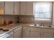 White kitchen with granite countertops, stainless steel sink, and ample natural light offers a clean and modern cooking space at 106 Weatherstone Dr # B, Chapel Hill, NC 27514