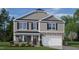 Charming two-story home features stone accents, gray siding, a two-car garage and a covered front porch at 112 Pisgah St, Sanford, NC 27330