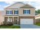 Two-story home featuring a stone veneer, attached two-car garage, and a well-maintained lawn at 112 Pisgah St, Sanford, NC 27330