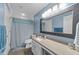 Bathroom featuring white cabinets, modern fixtures, a large mirror, and a shower with a blue shower curtain at 1201 Opeushaw Ct, Wake Forest, NC 27587