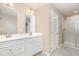 Bathroom featuring a double vanity, framed mirrors, and a glass-enclosed shower at 121 Mason Oaks Dr, Wake Forest, NC 27587