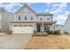 Charming two-story home with light blue siding, an attached garage, manicured lawn, and inviting curb appeal at 121 Mason Oaks Dr, Wake Forest, NC 27587