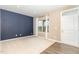 Cozy living room featuring a neutral color scheme, plush carpeting, ample natural light, and a modern interior door at 121 Mason Oaks Dr, Wake Forest, NC 27587