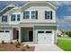Charming two-story townhome featuring a one-car garage, and a cozy covered entry, complemented by manicured landscaping at 129 Rolesville Ridge Dr, Rolesville, NC 27571