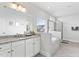 Bright bathroom featuring a soaking tub, glass shower, and granite countertop sink at 1530 Armscroft Ln, Apex, NC 27502