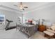 Spacious bedroom featuring a ceiling fan, large windows, a bed, and fitness equipment at 1530 Armscroft Ln, Apex, NC 27502