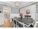 Open-concept dining room with wainscoting, chandelier, and view into other rooms at 1530 Armscroft Ln, Apex, NC 27502