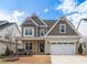 Charming two-story home featuring a welcoming front porch and a two-car garage at 1530 Armscroft Ln, Apex, NC 27502