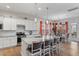 Bright, white kitchen featuring an island with barstool seating and stainless steel appliances at 1530 Armscroft Ln, Apex, NC 27502