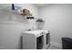Functional laundry room equipped with modern washer and dryer units, and shelving for storage at 1530 Armscroft Ln, Apex, NC 27502