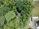 Home nestled among mature trees with a paved driveway at 1706 Us Hwy 70A E, Hillsborough, NC 27278
