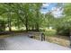 Wood back deck with gray stain overlooks the treed backyard with lush greenery at 1706 Us Hwy 70A E, Hillsborough, NC 27278
