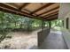 Back porch with wooden railing and exposed ceiling beams overlooks the spacious backyard at 1706 Us Hwy 70A E, Hillsborough, NC 27278