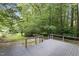 Spacious backyard with a gray wood deck and lush trees with greenery all around at 1706 Us Hwy 70A E, Hillsborough, NC 27278