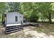 Wooden deck with stairs and mature trees in the backyard at 1706 Us Hwy 70A E, Hillsborough, NC 27278