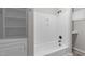 Bathroom featuring a shower-tub combo with bright white tile surround and a storage cabinet at 1706 Us Hwy 70A E, Hillsborough, NC 27278